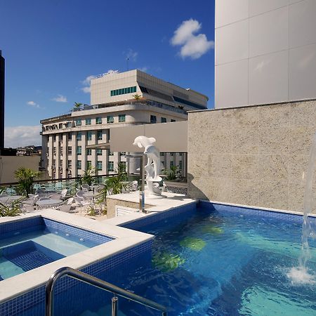 Hotel Atlântico Business Centro Rio de Janeiro Exterior foto The photo shows a rooftop area featuring a swimming pool and a spa. The pool is inviting with a clear blue water, and there appears to be a waterfall feature. Surrounding the pool are areas for relaxation, possibly with sun loungers. In the backgroun